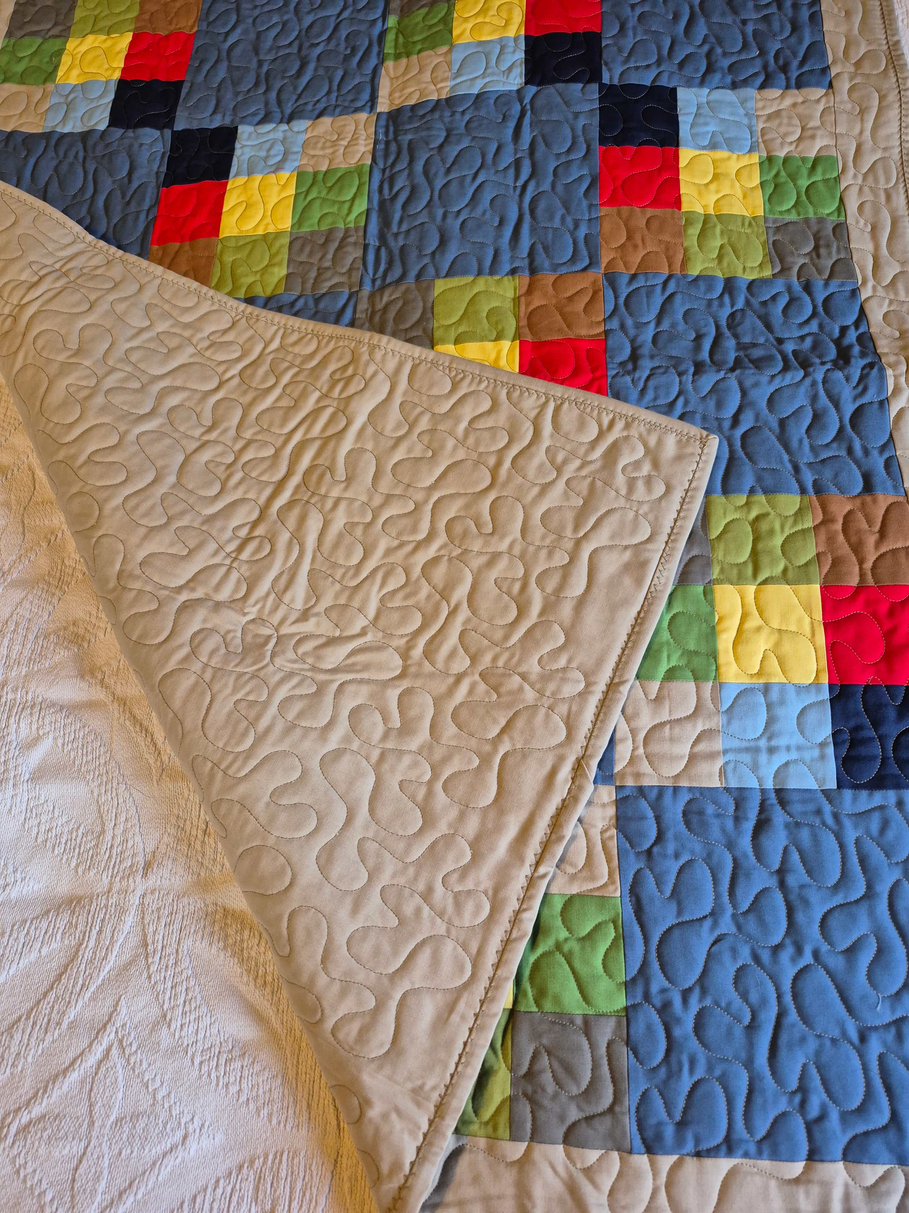 Patchwork quilt folded to show quilting detail on back