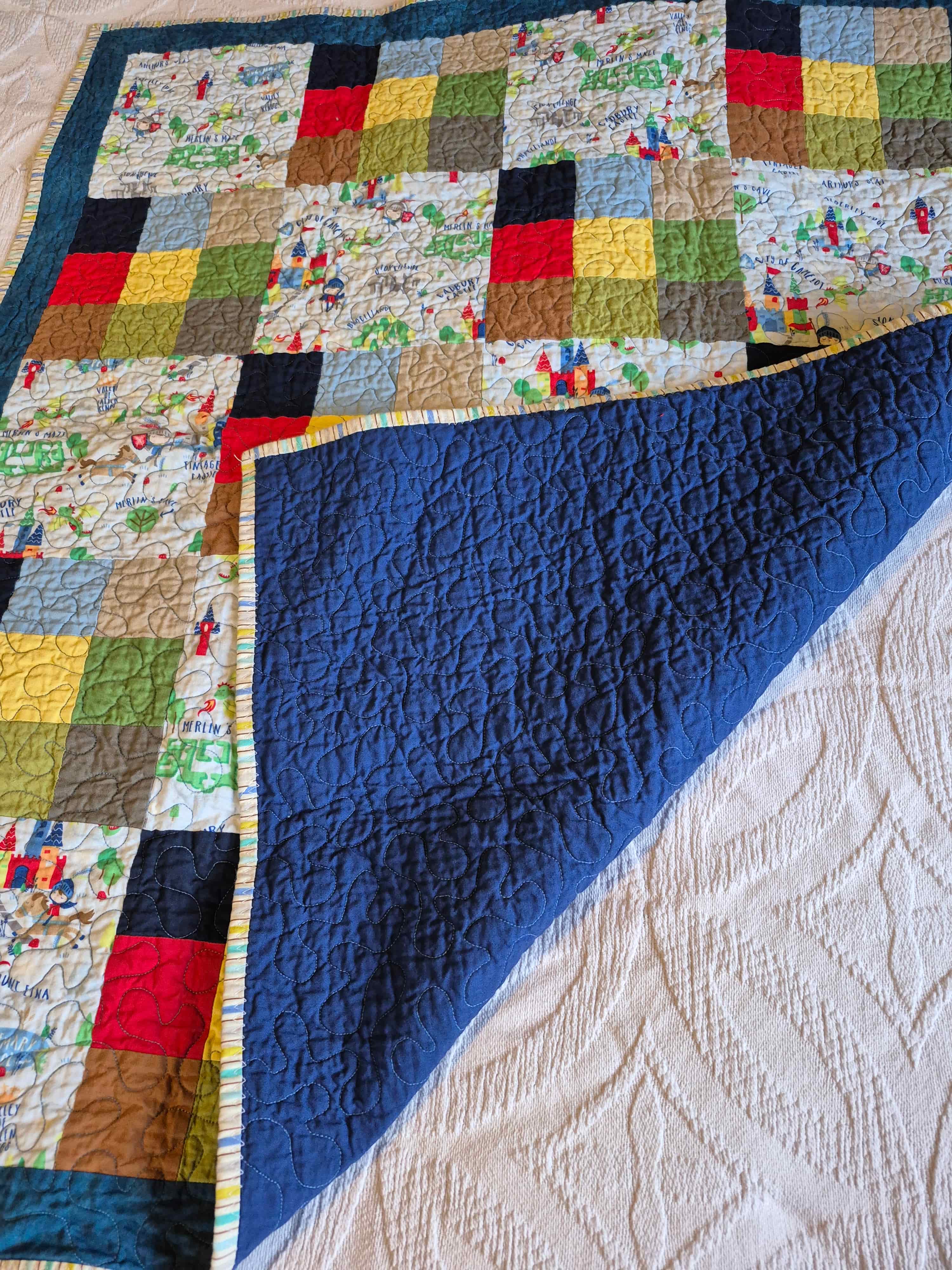 Castle quilt folded to show navy blue backing fabric